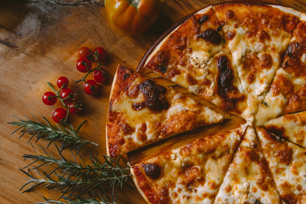 Pizza de queso con tomates y romero sobre una tabla